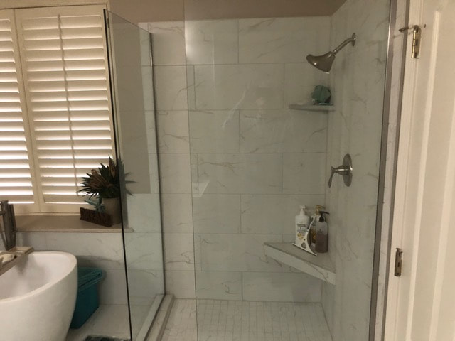 Bathroom remodel including new tile, tub, and shower. 